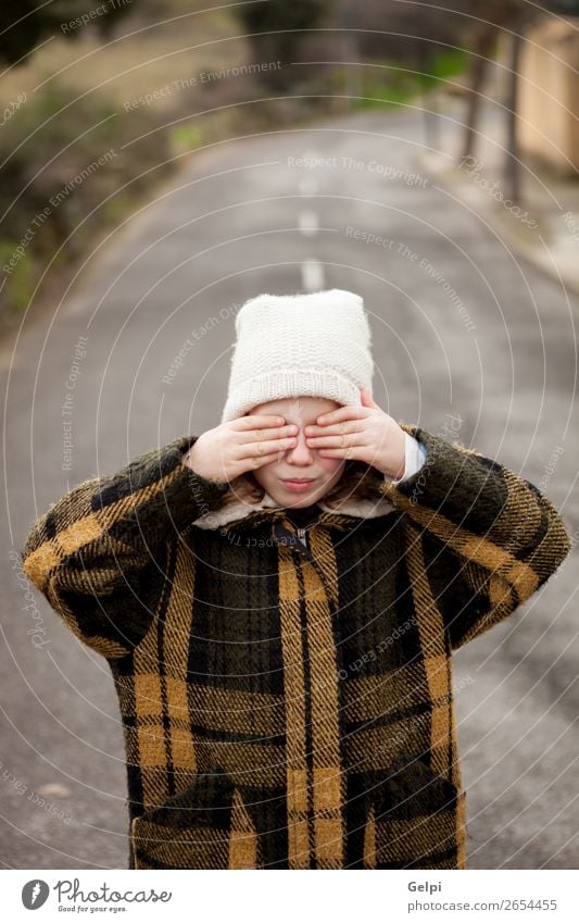 Schönes kleines Mädchen mit Wollmütze, die ihre Augen bedeckt. Freude schön Gesicht Spielen Winter Kind Mensch Kleinkind Frau Erwachsene