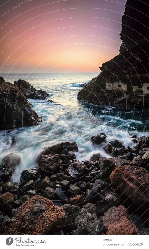 Meer schlägt leichte Wellen in felsige Bucht, Langzeitbelichtung Küste Wasser Insel Sonnenuntergang Stein Felsen Hütte Häuser Außenaufnahme Menschenleer Sommer