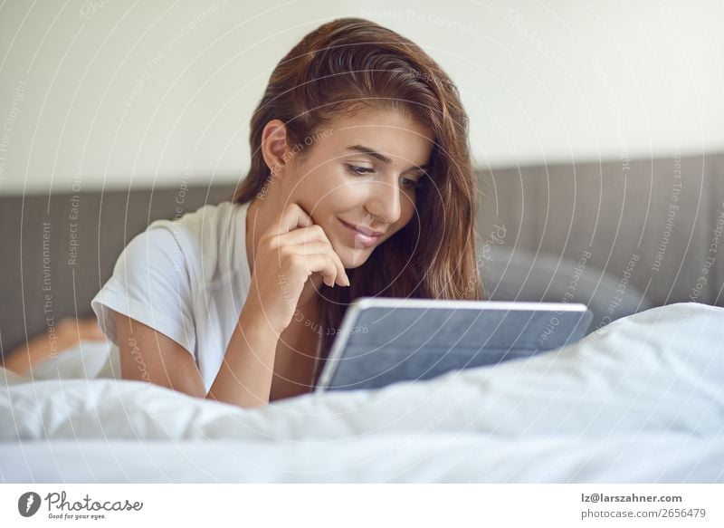 Hübsche junge Frau mit Tablette im Bett kaufen Glück schön Schlafzimmer Business Computer Technik & Technologie Internet Erwachsene 1 Mensch 18-30 Jahre