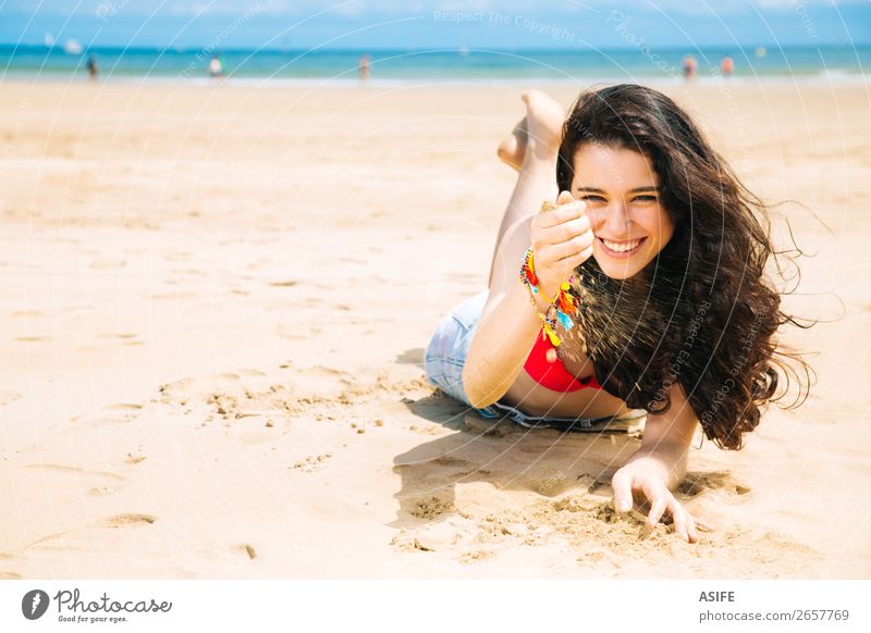 Fröhliche junge Frau am Strand Freude Glück schön Erholung Spielen Ferien & Urlaub & Reisen Sommer Sonne Sonnenbad Meer Erwachsene Hand Natur Sand Wind Küste