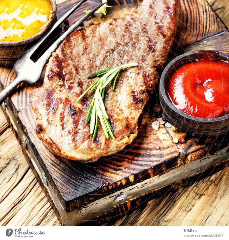 Rindersteak mit Rosmarinzweig Rindfleisch Steak Fleisch Lebensmittel gegrillt Barbecue gebraten Beefsteak Grillrost Saucen Ketchup Lendenstück hölzern Filet