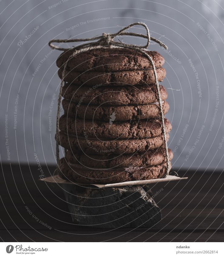 Stapel von runden Schokoladenkeksen, die mit einem Seil gebunden sind. Kuchen Dessert Süßwaren Ernährung Tisch Menschengruppe Essen dunkel lecker braun