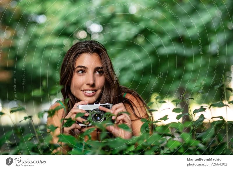 junge schöne Touristenfrau mit einer Fotokamera Lifestyle Glück Ferien & Urlaub & Reisen Tourismus Sommer Mensch Frau Erwachsene Baum Park Straße Mode Hut