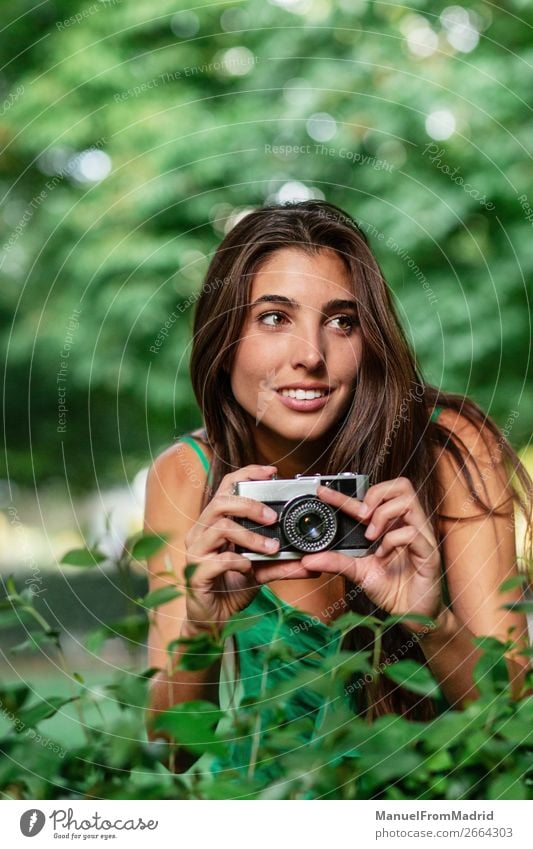 junge schöne Touristenfrau mit einer Fotokamera Lifestyle Glück Ferien & Urlaub & Reisen Tourismus Sommer Mensch Frau Erwachsene Baum Park Straße Mode Hut