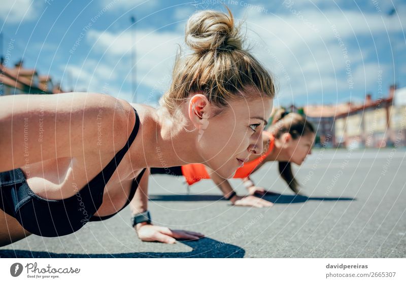 Zwei Sportlerinnen beim Liegestützen rollen Lifestyle schön Körperpflege Wellness Mensch Frau Erwachsene Freundschaft brünett blond Fitness sportlich stark