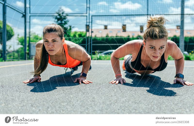 Sportlerinnen bei Liegestützen Lifestyle schön Körperpflege Mensch Frau Erwachsene Freundschaft brünett blond Fitness sportlich stark Kraft anstrengen Energie