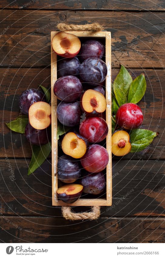 Frische Pflaumen mit Blättern Frucht Ernährung Vegetarische Ernährung Diät Schalen & Schüsseln Sommer Tisch Herbst Blatt Holz frisch saftig braun purpur roh