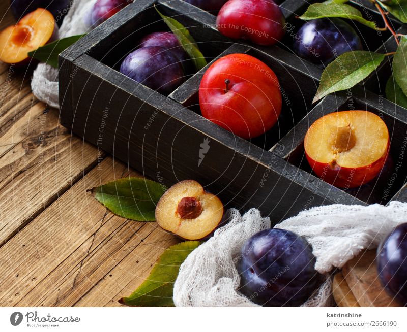 Frische Pflaumen mit Blättern Frucht Ernährung Vegetarische Ernährung Diät Schalen & Schüsseln Sommer Tisch Herbst Blatt Holz frisch saftig braun purpur roh