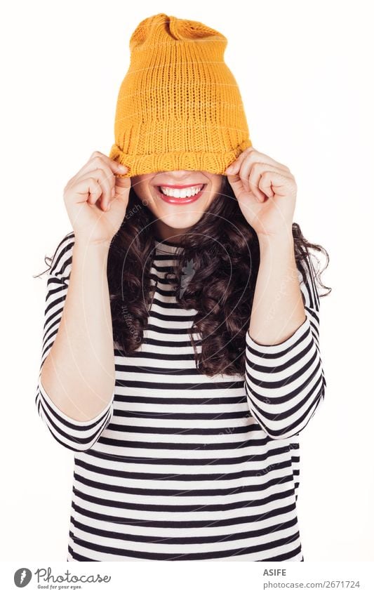 Fröhliches Herbst- oder Wintermädchen, das das Gesicht mit Wollmütze bedeckt. Glück schön Frau Erwachsene Zähne Kleid Lächeln Fröhlichkeit lustig gelb schwarz