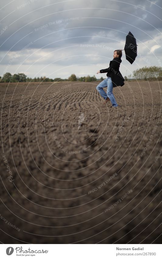 stürmische Zeiten maskulin Junger Mann Jugendliche 1 Mensch schlechtes Wetter Wind Mantel Regenschirm fliegen laufen Feld acker windig davon Unwetter wolken