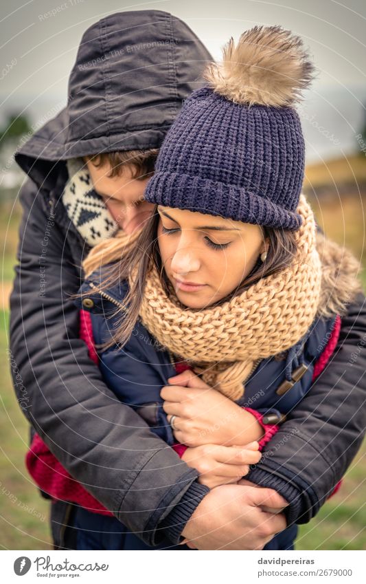 Junges Paar mit Hut und Schal, das sich im Freien umarmt. Lifestyle Glück schön Winter Frau Erwachsene Mann Natur Himmel Wolken Herbst Wind Wärme Bekleidung