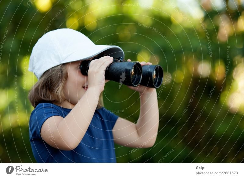 Kleines süßes Mädchen im Park, das mit einem Fernglas aussieht. Freude Glück schön Gesicht Leben Freizeit & Hobby Ferien & Urlaub & Reisen Camping Sommer Kind