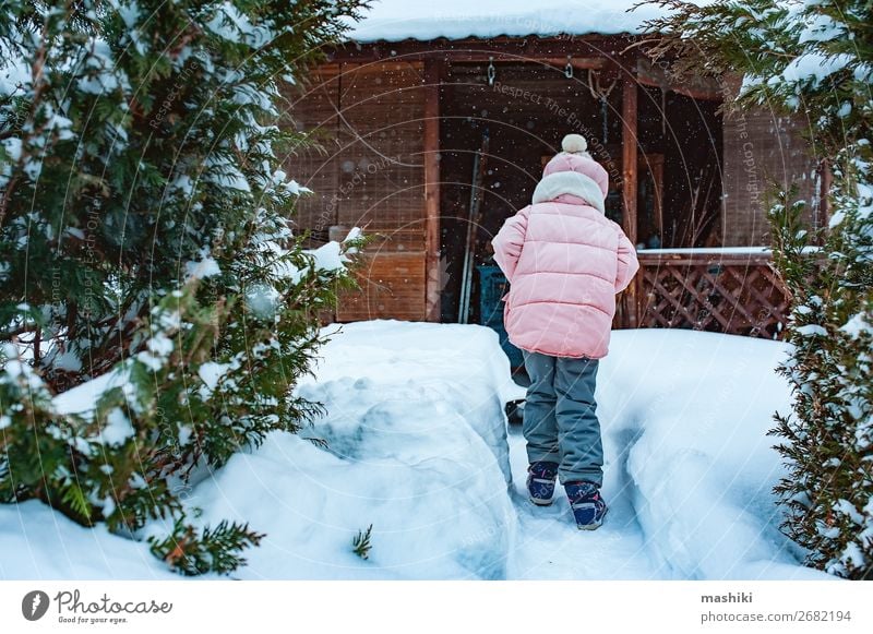 Kind Mädchen hilft, den Weg vom Schnee zu reinigen mit Schaufel Spielen Winter Haus Garten Werkzeug Wetter Unwetter Schneefall Fröhlichkeit Sauberkeit kalt