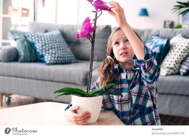 fröhliches Kind Mädchen mit Orchideenblume im Topf. Lifestyle exotisch schön Gartenarbeit Pflanze Blume Blatt Wachstum klein rosa rein fürsorglich Zimmerpflanze