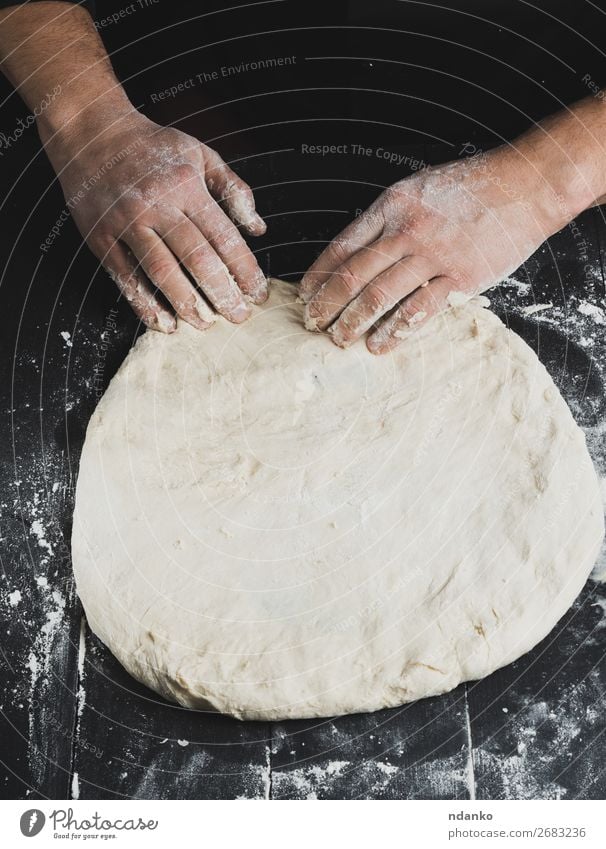 Männerhände kneten ein rundes Stück Teig. Teigwaren Backwaren Brot Ernährung Tisch Küche Koch Mensch Hand Holz machen weiß Pizza Bäckerei Mehl Kneten Küchenchef