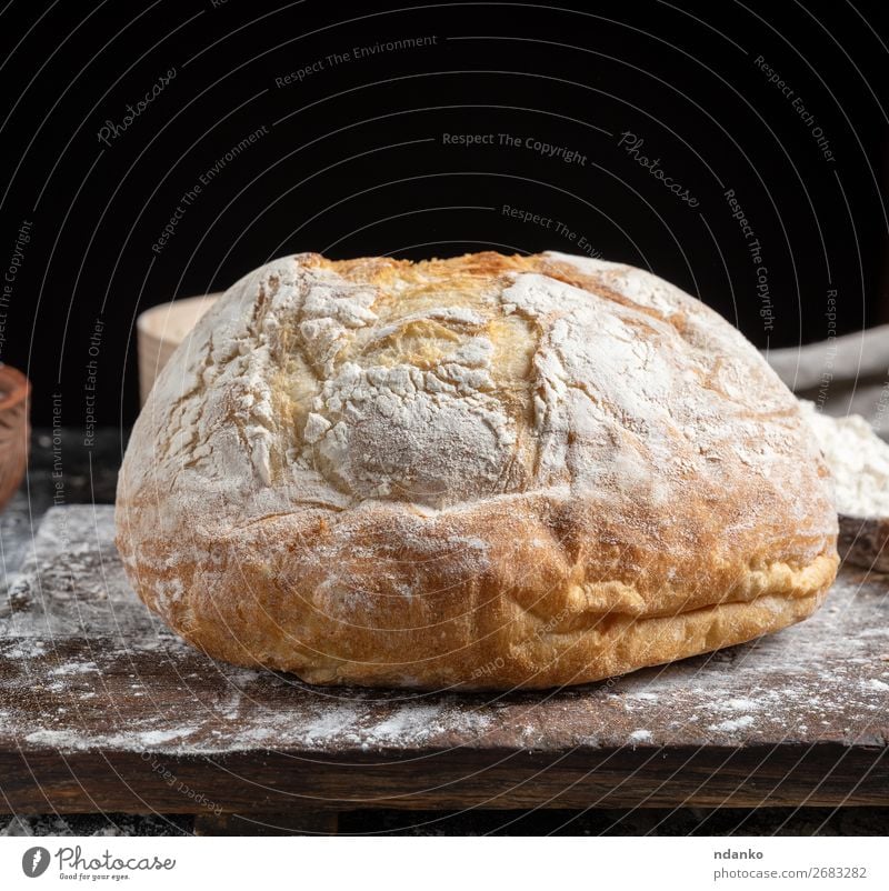 ganzes gebackenes Rundbrot Brot Ernährung Tisch Küche Holz machen dunkel frisch braun schwarz weiß Tradition Bäckerei Holzplatte Essen zubereiten Schneidebrett