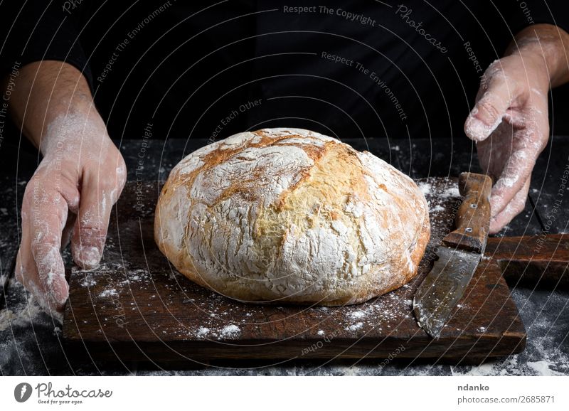 rund gebackenes hausgemachtes Brot Lebensmittel Teigwaren Backwaren Tisch Küche Hand Holz machen dunkel frisch braun schwarz weiß Tradition Bäckerei Holzplatte