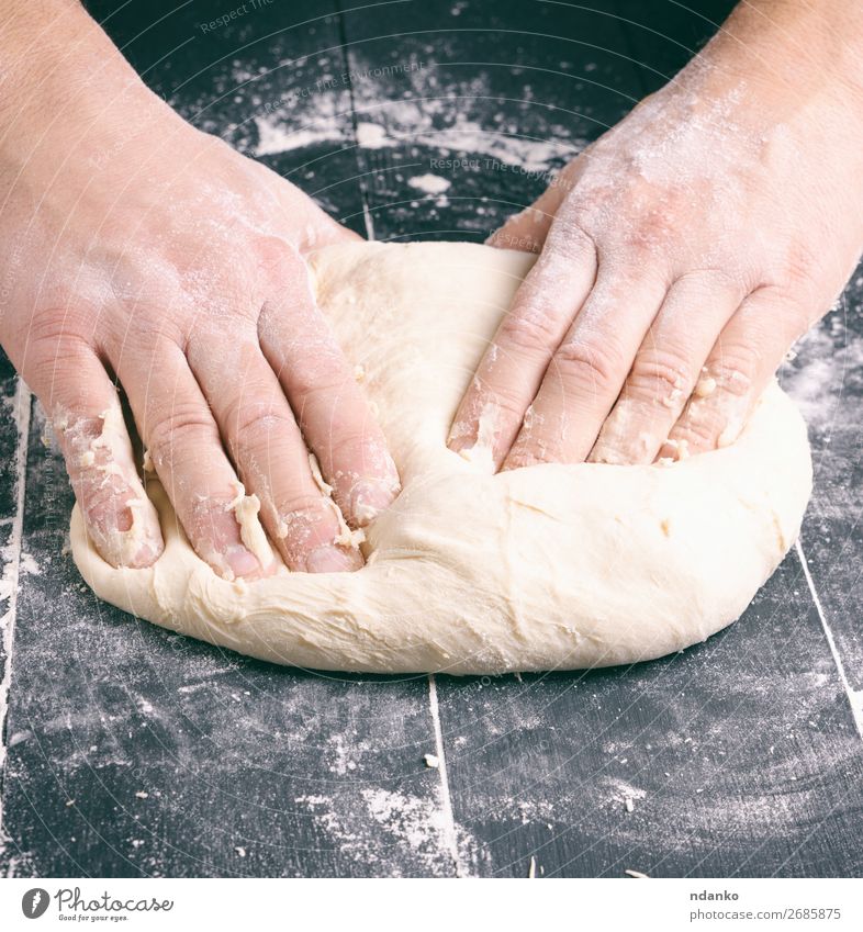 männliche Hände ersetzen weißen Weizenmehlteig Teigwaren Backwaren Brot Ernährung Tisch Küche Mann Erwachsene Hand Holz machen schwarz Tradition backen Bäcker