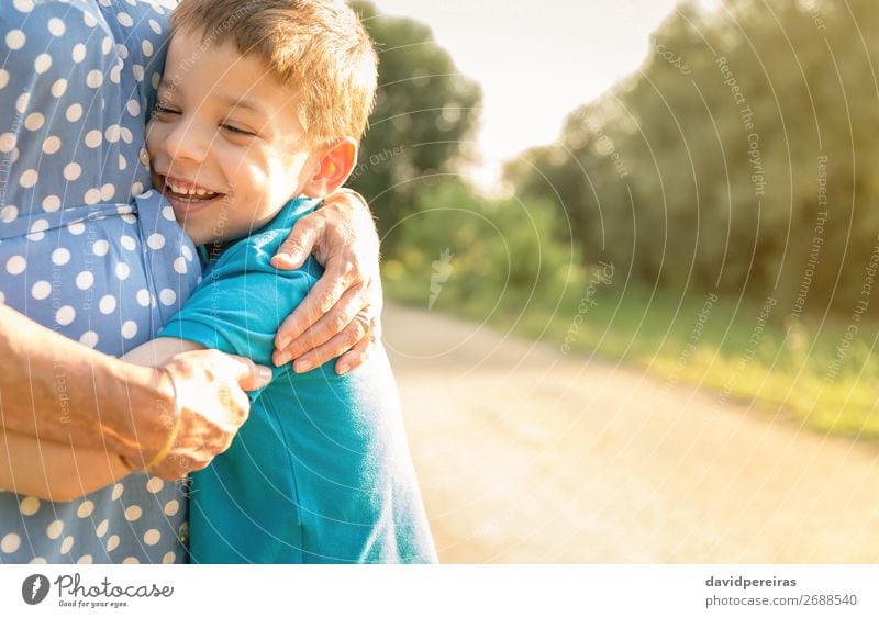 Glücklicher Enkel, der seine Großmutter im Freien umarmt. Lifestyle Erholung Freizeit & Hobby Sommer Garten Kind Mensch Junge Frau Erwachsene Mann Eltern