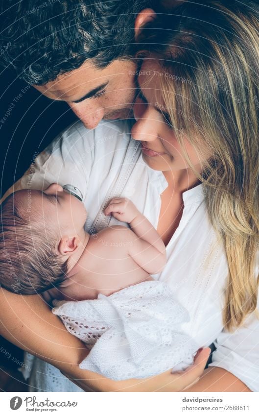 Paar umarmt ein Neugeborenes auf dunklem Hintergrund Lifestyle Glück schön Kind Mensch Baby Kleinkind Frau Erwachsene Mann Eltern Mutter Vater