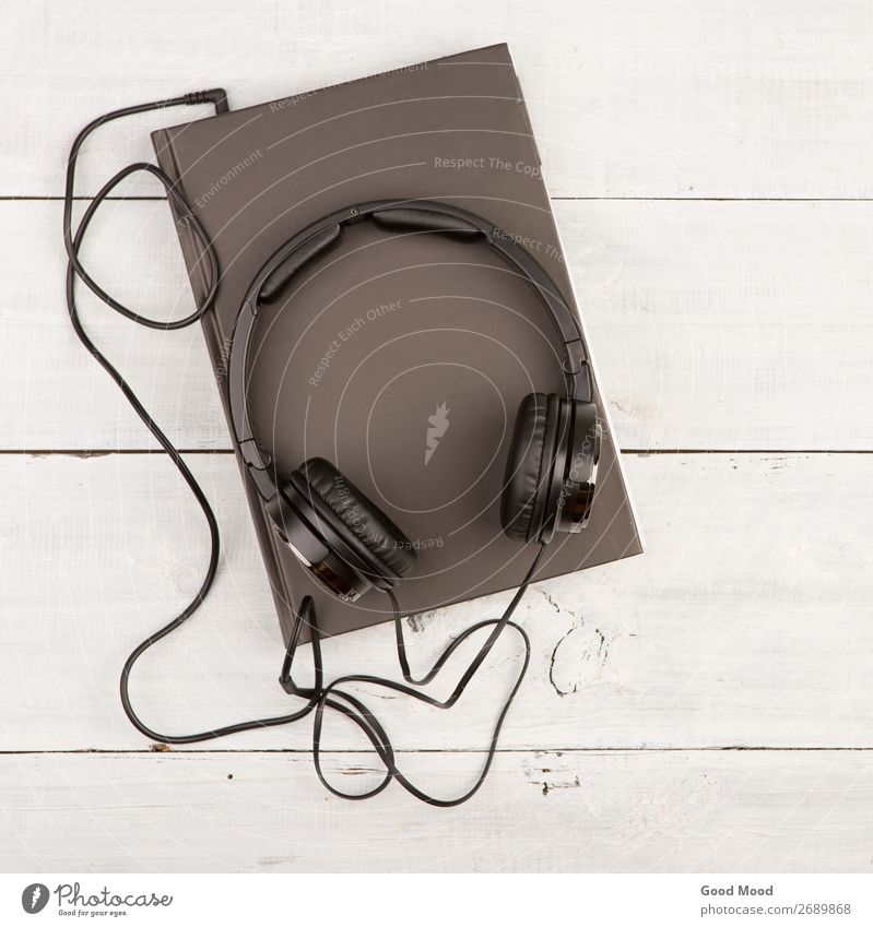 Hörbuchkonzept mit Black Book und Kopfhörern Freizeit & Hobby Spielen lesen Musik Schule lernen Headset Technik & Technologie Medien Buch Bibliothek Papier Holz