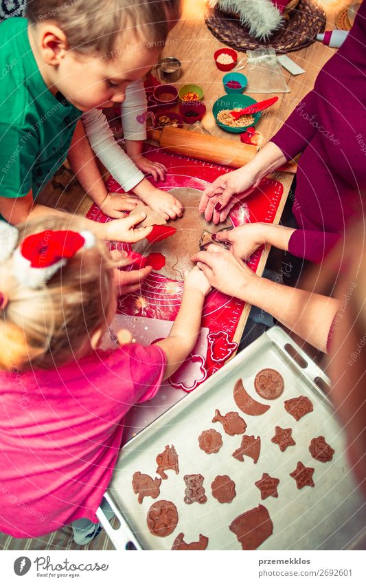 Weihnachtsplätzchen backen. Weihnachtliche Lebkuchen in vielen Formen, dekoriert mit buntem Zuckerguss, bestreuen, glasieren, mit Kuvertüre überziehen, Topper, auf den Tisch stellen. Backen von traditionellen Keksen. Familie feiert Weihnachten. Backen zu Hause. Gebackener süßer Keks