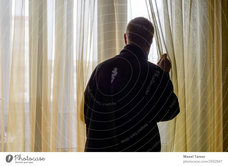 Mann schaut aus dem Fenster. Mensch Erwachsene beobachten Denken stehen warten Hintergrundbeleuchtung hintergrundbeleuchtet Kaukasier Gardine heimwärts