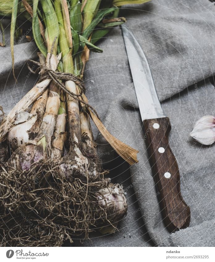 junger Knoblauch in einem Bündel gebunden Gemüse Kräuter & Gewürze Ernährung Vegetarische Ernährung Messer Tisch Natur Pflanze Blatt Holz frisch natürlich braun