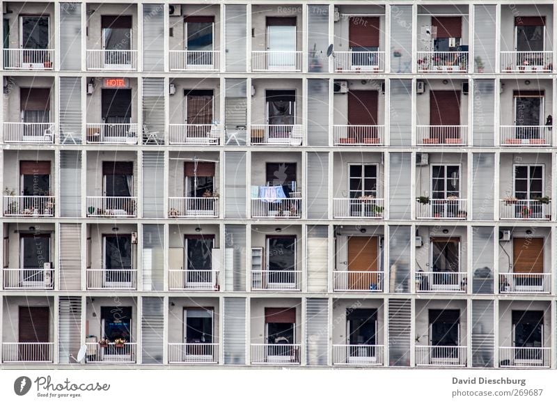 Normiertes Wohnen Stadt überbevölkert Haus Hochhaus Bauwerk Fassade Balkon Fenster Tür Rollladen Geländer Rechteck Symmetrie Fensterscheibe Farbfoto