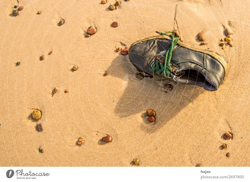 alter, verlorener Schuh am Strand Sommer Sand Sonne Ostsee braun Traurigkeit Sandstrand Fund Steine Kiesel Stilleben Urlaub Farbfoto Außenaufnahme Menschenleer