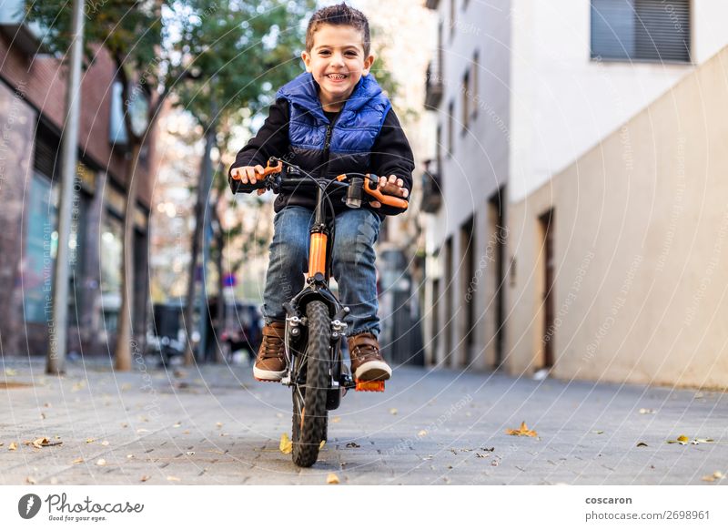 Kleines Kind fährt mit dem Fahrrad auf der Stadtstraße. Lifestyle Freude Glück schön Gesicht Erholung Freizeit & Hobby Spielen Kinderspiel Sommer Sonne Sport