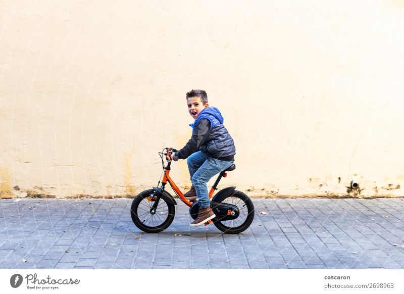 Kleines Kind fährt mit dem Fahrrad auf der Stadtstraße. Lifestyle Freude Glück Erholung Freizeit & Hobby Spielen Kinderspiel Sommer Sonne Sport Erfolg