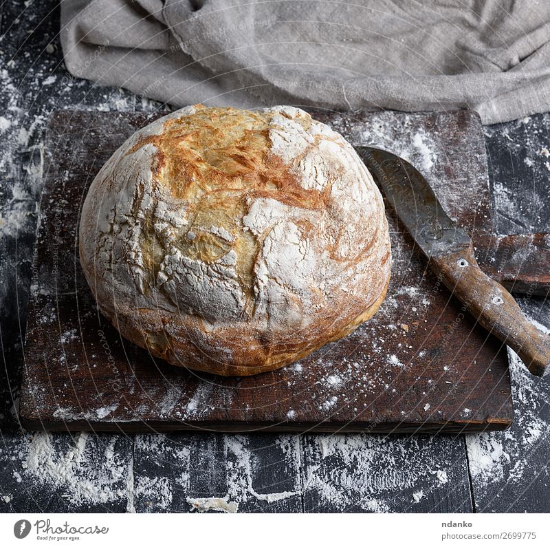 gebackenes weißes Weizenbrot Brot Ernährung Tisch Küche Holz machen dunkel frisch braun schwarz Tradition Bäckerei Holzplatte Essen zubereiten Kruste