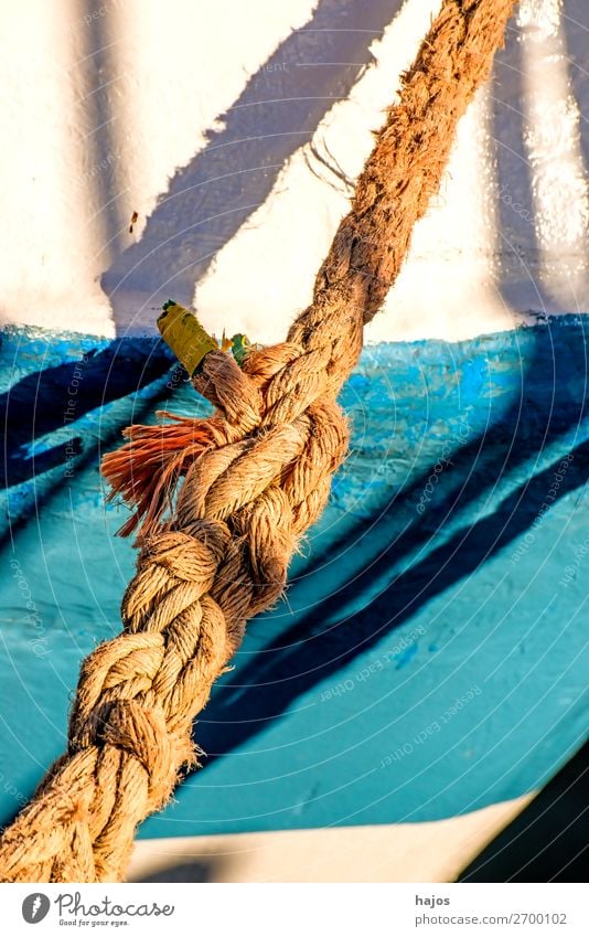 Alte Festmacherleine an einem Fischkutter Design maritim blau mehrfarbig weiß Schiff Schiffswand weiß blau Licht Schatten sonni Hafen verzurrt Schifffahrt alt