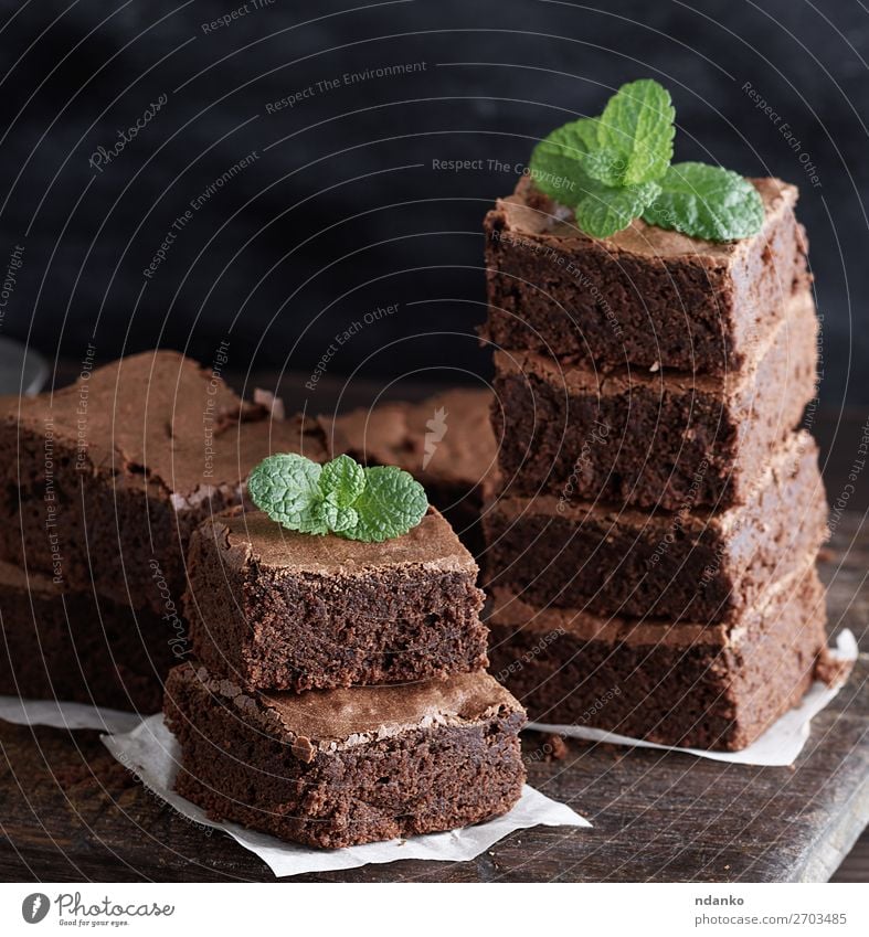 Stapel von quadratischen Stücken von gebackenem braunem Brownie Pie. Kuchen Dessert Süßwaren Ernährung Tisch Blatt Holz dunkel frisch lecker grün schwarz