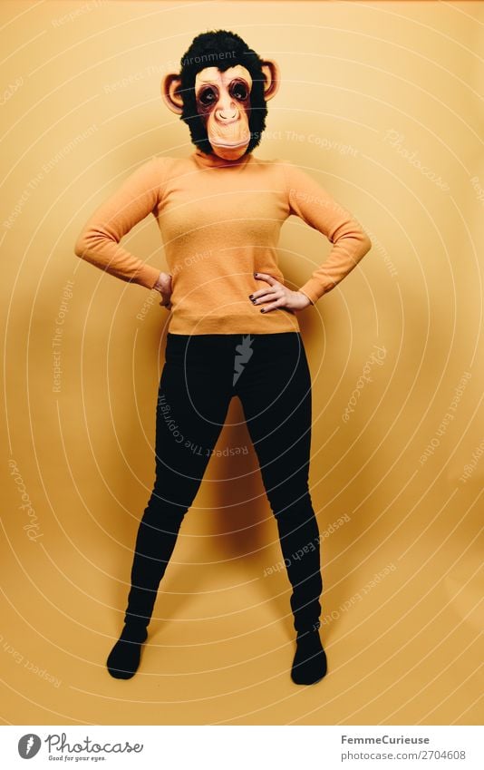 Woman with monkey mask posing against a yellow background feminin Frau Erwachsene 1 Mensch 18-30 Jahre Jugendliche 30-45 Jahre Freude Karneval Karnevalskostüm