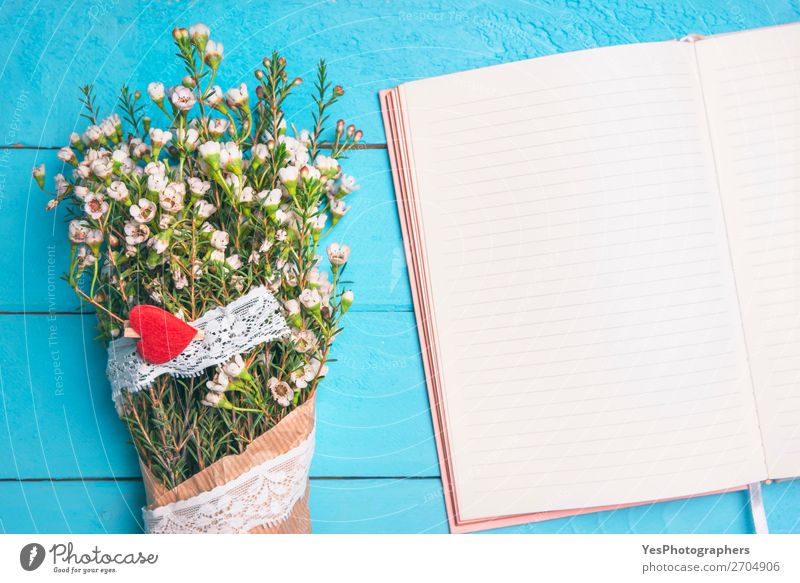 Leeres, offenes Notizbuch und weiße Blumen. Flache Auflage eines Frauentisches. Schreibtisch Muttertag Hochzeit Geburtstag Arbeitsplatz Büro Blumenstrauß Herz