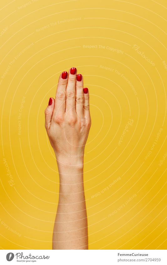 Forearm and hand of a woman in front of a yellow background feminin Junge Frau Jugendliche Erwachsene 1 Mensch 18-30 Jahre 30-45 Jahre gelb rot Nagellack