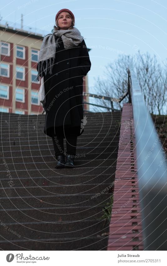 Frau Treppe Backstein Rot Hamburg Geländer Fenster Mantel Schal Mütze Blick stehen warten groß rot schwarz achtsam Wachsamkeit Kontrolle stagnierend Farbfoto