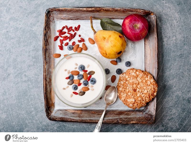 Frühstück auf dem Tisch. Joghurt mit Heidelbeer- und Mandelnzusatz Lebensmittel Milcherzeugnisse Frucht Apfel Getreide Brot Dessert Ernährung Essen Mittagessen