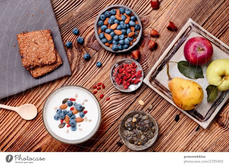 Frühstück auf dem Tisch. Joghurt mit Heidelbeer- und Mandelnzusatz Lebensmittel Milcherzeugnisse Frucht Apfel Getreide Brot Dessert Ernährung Essen Mittagessen