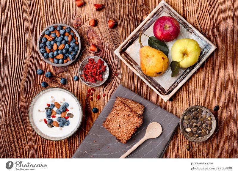 Frühstück auf dem Tisch. Joghurt mit Heidelbeer- und Mandelnzusatz Lebensmittel Milcherzeugnisse Frucht Apfel Getreide Brot Dessert Ernährung Essen Mittagessen