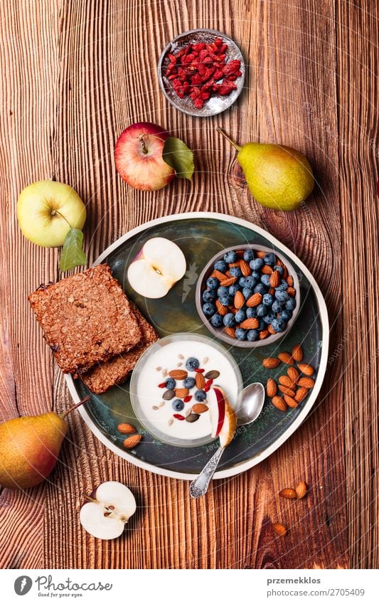 Frühstück auf dem Tisch. Joghurt mit Heidelbeer- und Mandelnzusatz Lebensmittel Milcherzeugnisse Frucht Apfel Getreide Brot Dessert Ernährung Essen Mittagessen