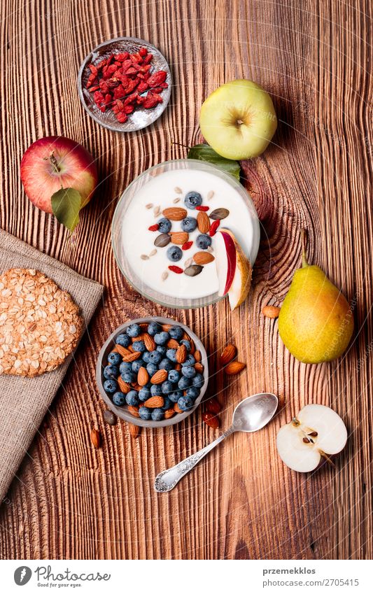 Frühstück auf dem Tisch. Joghurt mit Heidelbeer- und Mandelnzusatz Lebensmittel Milcherzeugnisse Frucht Apfel Brot Dessert Ernährung Essen Mittagessen