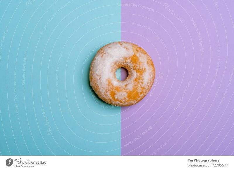 Einzelner Donut auf blau-violettem Hintergrund. Minimalistische flache Verlegung Dessert Frühstück rosa obere Ansicht backen Bäckerei zweifarbig Kuchen Konfekt