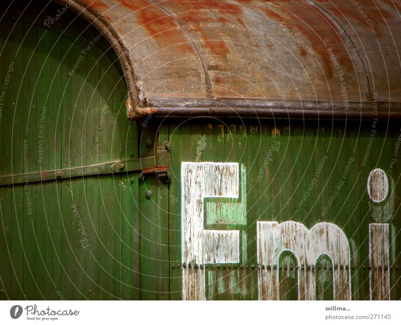 Emi Buchstaben Schriftzeichen Text alt historisch Bauwagen Anhänger Eisenbahnwaggon Verfall Vergangenheit Vergänglichkeit Wandel & Veränderung emi Holzwand grün