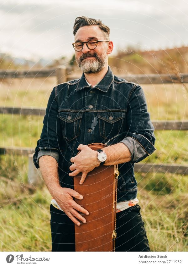 Erwachsener Mann mit Gitarrenkoffer Natur Musiker fallen stehen ländlich Zaun Lifestyle Mensch Sommer lässig akustisch gutaussehend Typ Freizeit & Hobby