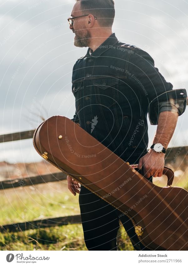 Erwachsener Mann mit Gitarrenkoffer Natur Musiker fallen stehen Wegsehen ländlich Zaun Lifestyle Mensch Sommer lässig akustisch gutaussehend Typ