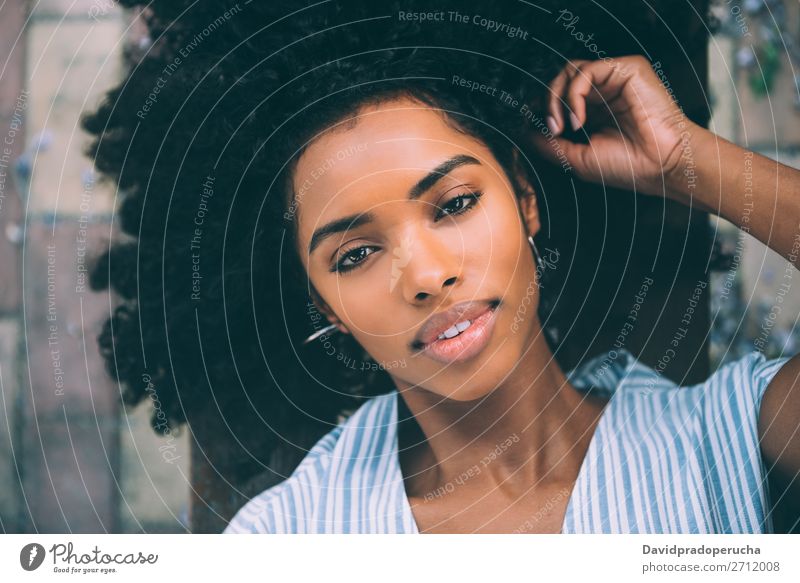 Schöne junge schwarze Frau, die sich auf einem Stuhl in einem Park niederlässt. Beautyfotografie Nahaufnahme Porträt multiethnisch Afrikanisch