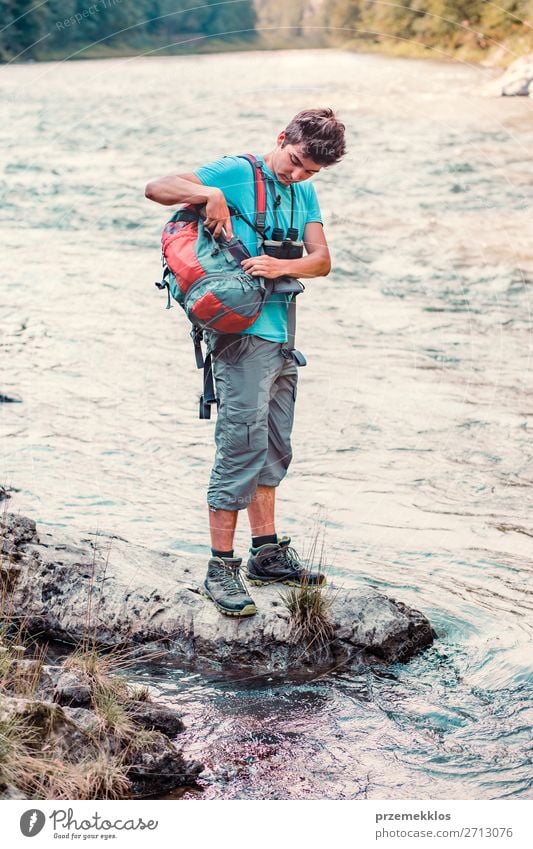 Der kleine Junge nimmt einen Becher heraus, um reines Wasser aus einem Fluss zu holen. Leben Ausflug Abenteuer Sommer wandern Mensch Junger Mann Jugendliche